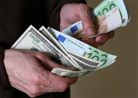 simsearch:400-06921414,k - Man's hands hold Euro and dollars banknotes money Photographie de stock - Aubaine LD & Abonnement, Code: 400-05054510