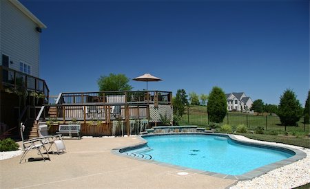 stone exterior suburban home - Backyard Pool in summer with surrounding multi-level deck Stock Photo - Budget Royalty-Free & Subscription, Code: 400-05054654