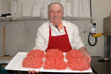 Butcher presenting tray of minced beef (ground beef) ready for hamburgers / beefburgers Foto de stock - Super Valor sin royalties y Suscripción, Código: 400-05055792