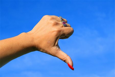 simsearch:400-04049823,k - Woman's hand showing thumb down sign over blue sky. Foto de stock - Royalty-Free Super Valor e Assinatura, Número: 400-05056318