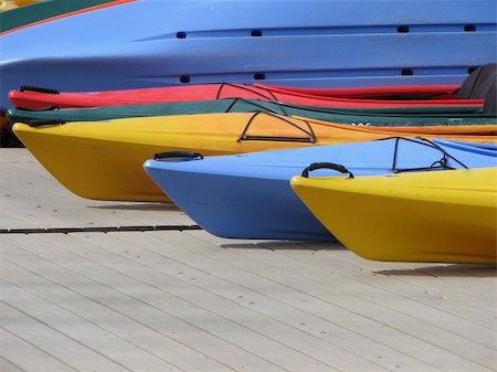 Blue, yellow, green, and red kayaks on dock in summer sunlight. Stock Photo - Budget Royalty-Free & Subscription, Code: 400-05056472