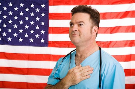 simsearch:400-04217553,k - Patriotic doctor saying the Pledge of Allegiance to the American flag.  Photographed in front of flag, not a composite image. Foto de stock - Royalty-Free Super Valor e Assinatura, Número: 400-05056557