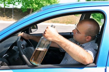 simsearch:400-04947548,k - Drunk man sitting in drivers and holding a bottle alcohol Stock Photo - Budget Royalty-Free & Subscription, Code: 400-05057539