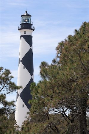 A historic lighthouse guiding ships away from rocky shoals. Stock Photo - Budget Royalty-Free & Subscription, Code: 400-05058101