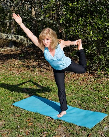 Beautiful 60 year old woman doing advanced pilates pose in a natural setting. Stock Photo - Budget Royalty-Free & Subscription, Code: 400-05058202