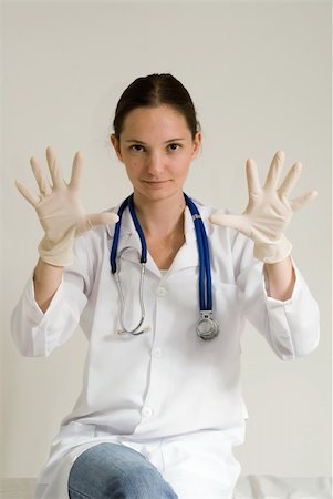 Young female doctor holding out her gloved hands. Isolated. Stock Photo - Budget Royalty-Free & Subscription, Code: 400-05058366