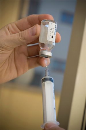 hand holding a vial of a medicinal and a syringe Stockbilder - Microstock & Abonnement, Bildnummer: 400-05059772