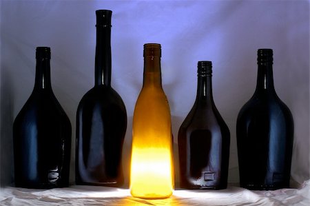 some glass bottles standing in a line and one is shining Stock Photo - Budget Royalty-Free & Subscription, Code: 400-05050397