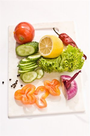 Vegetable mix: lettuce, onion, lemon, cucumber on the board Stock Photo - Budget Royalty-Free & Subscription, Code: 400-05051340