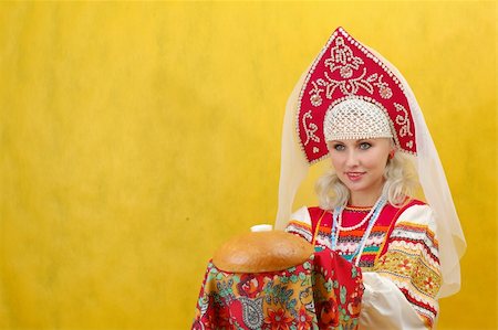 simsearch:400-05051542,k - Russian woman in a folk russian dress Holds a bread on yellow background Stock Photo - Budget Royalty-Free & Subscription, Code: 400-05051538