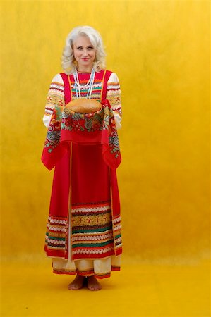 simsearch:400-05051542,k - Russian woman in a folk russian dress Holds a bread on yellow background Stock Photo - Budget Royalty-Free & Subscription, Code: 400-05051541