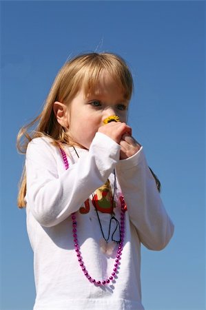 Small girl smelling a flower in the sunshine Foto de stock - Royalty-Free Super Valor e Assinatura, Número: 400-05051782