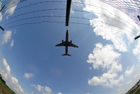 A silhouette of an aeroplane looks like to hit a fence. Stockbilder - Microstock & Abonnement, Bildnummer: 400-05052232