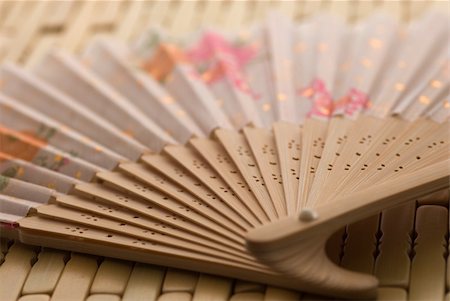 Oriental wooden fan on bamboo mat Stockbilder - Microstock & Abonnement, Bildnummer: 400-05052389