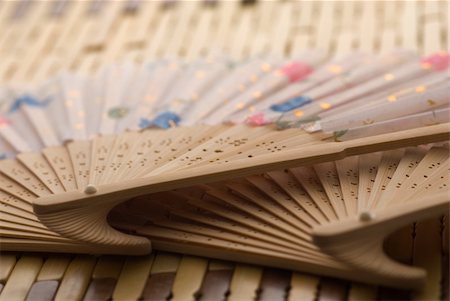 Oriental wooden fan on bamboo mat Stockbilder - Microstock & Abonnement, Bildnummer: 400-05052390