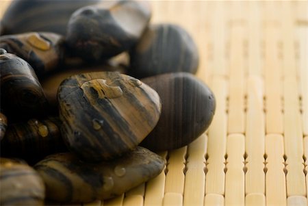 Frangipani flower and polished stone on tropical bamboo mat Stockbilder - Microstock & Abonnement, Bildnummer: 400-05052401