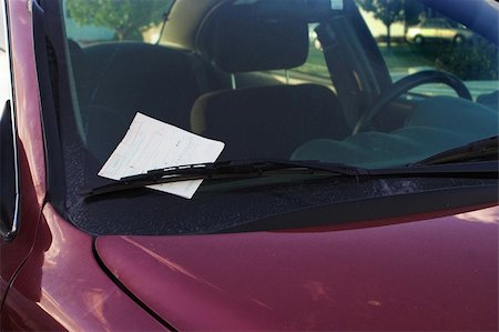 A parking ticket loving placed under the windshield wiper of a car. Fotografie stock - Microstock e Abbonamento, Codice: 400-05052423
