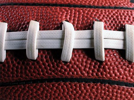 pigskin - Close-up shot showing the white laces and dimpled surface of an American football. Photographie de stock - Aubaine LD & Abonnement, Code: 400-05053214