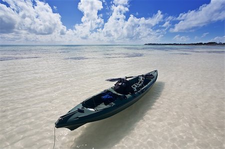 A small canoe drifting in the water under a fantastic sky. Beautiful white sands beach at Bahia Honda State Park in Florida. Foto de stock - Royalty-Free Super Valor e Assinatura, Número: 400-05053336