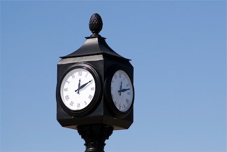 dragon_fang (artist) - An outdoor clock telling the time, shot against a blue sky Fotografie stock - Microstock e Abbonamento, Codice: 400-05053676