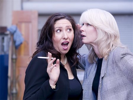 Two women engaging in gossip during a smoking break Stockbilder - Microstock & Abonnement, Bildnummer: 400-05053816