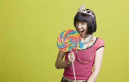 simsearch:400-05054627,k - Pretty young woman takes a bite from a large lollipop Stock Photo - Budget Royalty-Free & Subscription, Code: 400-05053812