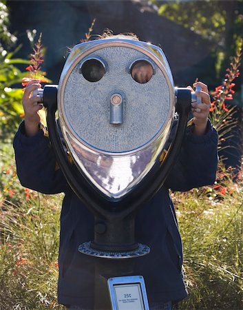 person focusing telescope - Girl using a telescope looking towards the camera Stock Photo - Budget Royalty-Free & Subscription, Code: 400-05053915