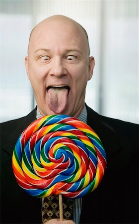 Businessman portrait with a brightly colered big lollipop Stock Photo - Budget Royalty-Free & Subscription, Code: 400-05053958