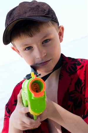 pistola de agua - A boy on the beach with his water gun Photographie de stock - Aubaine LD & Abonnement, Code: 400-05064899