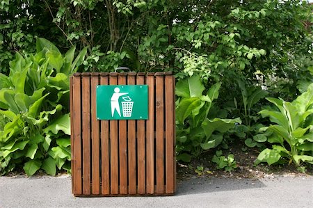 Slatted wooden litter bin with a green and white sign standing on a pathway with shrubs to the rear. Stock Photo - Budget Royalty-Free & Subscription, Code: 400-05066115