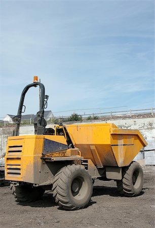 simsearch:400-05111345,k - Yellow dumper truck standing idle on rough ground. Fotografie stock - Microstock e Abbonamento, Codice: 400-05066118