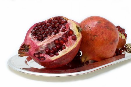 Ripe red pomegranate in a plate on a white background. Stockbilder - Microstock & Abonnement, Bildnummer: 400-05066317