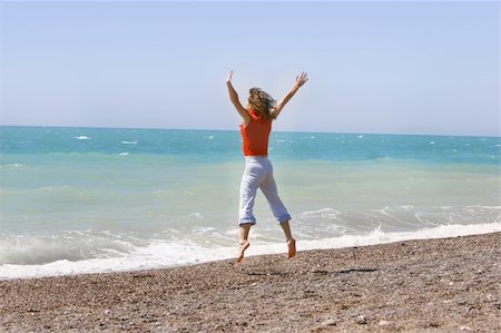 simsearch:400-04982004,k - Young woman jumping happily on the beach Stock Photo - Budget Royalty-Free & Subscription, Code: 400-05066489