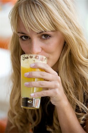 fabthi (artist) - Beautiful blonde woman drinking from a glass of fresh orange-juice looking in the camera Foto de stock - Super Valor sin royalties y Suscripción, Código: 400-05068037