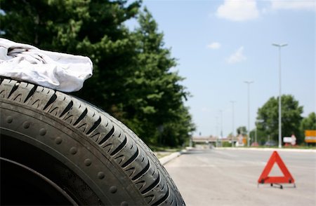 simsearch:400-05265745,k - Car tire and a red triangle on the road Foto de stock - Royalty-Free Super Valor e Assinatura, Número: 400-05068295