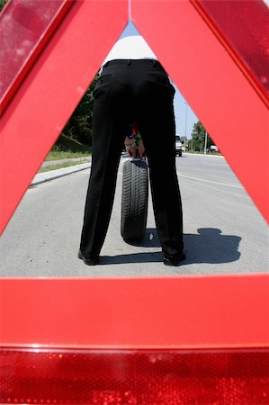 simsearch:400-07252682,k - man wth a flat tire and a triangle on the road Fotografie stock - Microstock e Abbonamento, Codice: 400-05068347