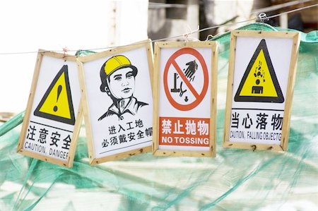 Various signs in English and Chinese to pay attention to a dangerous zone nearby a construction site. Fotografie stock - Microstock e Abbonamento, Codice: 400-05062058