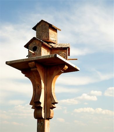 A wooden birdhouse on top of a pole with clouds in the background Stock Photo - Budget Royalty-Free & Subscription, Code: 400-05074231