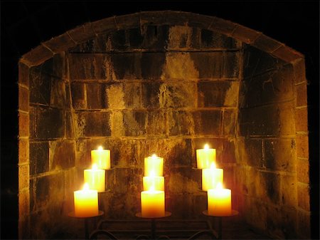 fuliggine - This is a set of nine candles burning in the fireplace. Might make a nice photo to depict the holidays or romance. Fotografie stock - Microstock e Abbonamento, Codice: 400-05074628