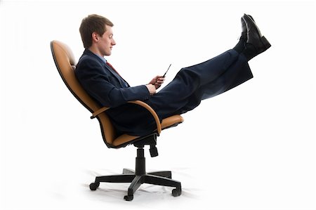 Coffee-break. Young businessman relaxed in chair and look at phone. Isolated over white Stock Photo - Budget Royalty-Free & Subscription, Code: 400-05075327