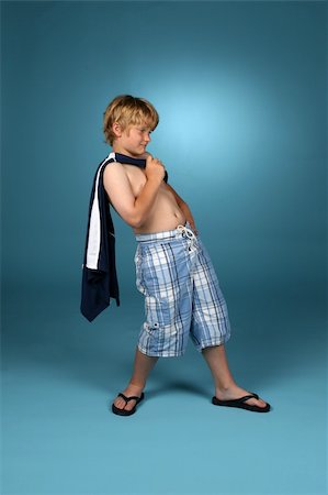 Boy in baggy blue plaid shorts with his shirt slung over one shoulder. Stock Photo - Budget Royalty-Free & Subscription, Code: 400-05077636