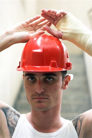 tattooed man with red helmet and hand in plaster Stockbilder - Microstock & Abonnement, Bildnummer: 400-05078546