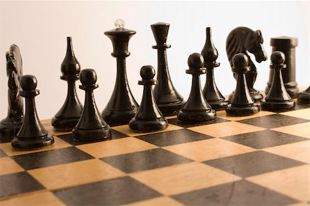 simsearch:400-04398584,k - Black chess are placed on a wooden chess board for the beginning games Fotografie stock - Microstock e Abbonamento, Codice: 400-05070049