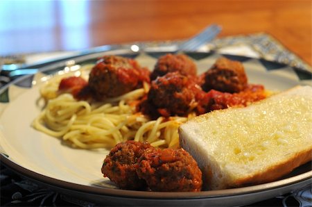 pane all'aglio - Full Meal with out of focus background of the spaghetti and meatballs, with delicious garlic bread in focus. Fotografie stock - Microstock e Abbonamento, Codice: 400-05070393