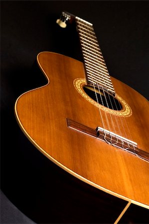 Part of an acoustic guitar on a black background. Fotografie stock - Microstock e Abbonamento, Codice: 400-05071670