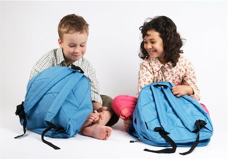 Two kids going on a vacation packing their backpacks. Or use it as two kids packing for school... Fotografie stock - Microstock e Abbonamento, Codice: 400-05071671