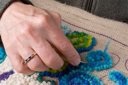 Detail showing a hand hooking a rug, a traditional maritime craft that recyles old fabrics into vibrant mats using burlap. Stockbilder - Microstock & Abonnement, Bildnummer: 400-05072640
