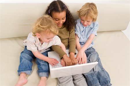 simsearch:400-04575374,k - Three young children using a laptop together while sitting on a settee Stock Photo - Budget Royalty-Free & Subscription, Code: 400-05085479