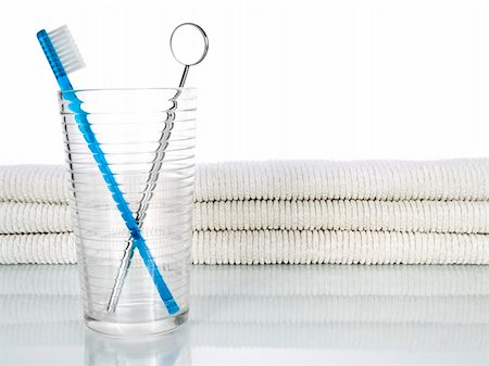 simsearch:400-04552289,k - A blue toothbrush and a mouth mirror in a glass on a background with a few towels. Foto de stock - Super Valor sin royalties y Suscripción, Código: 400-05085819