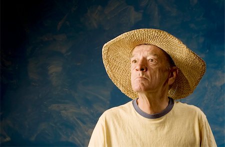 Senior man in a straw hat in front of blue set wall Stock Photo - Budget Royalty-Free & Subscription, Code: 400-05080079